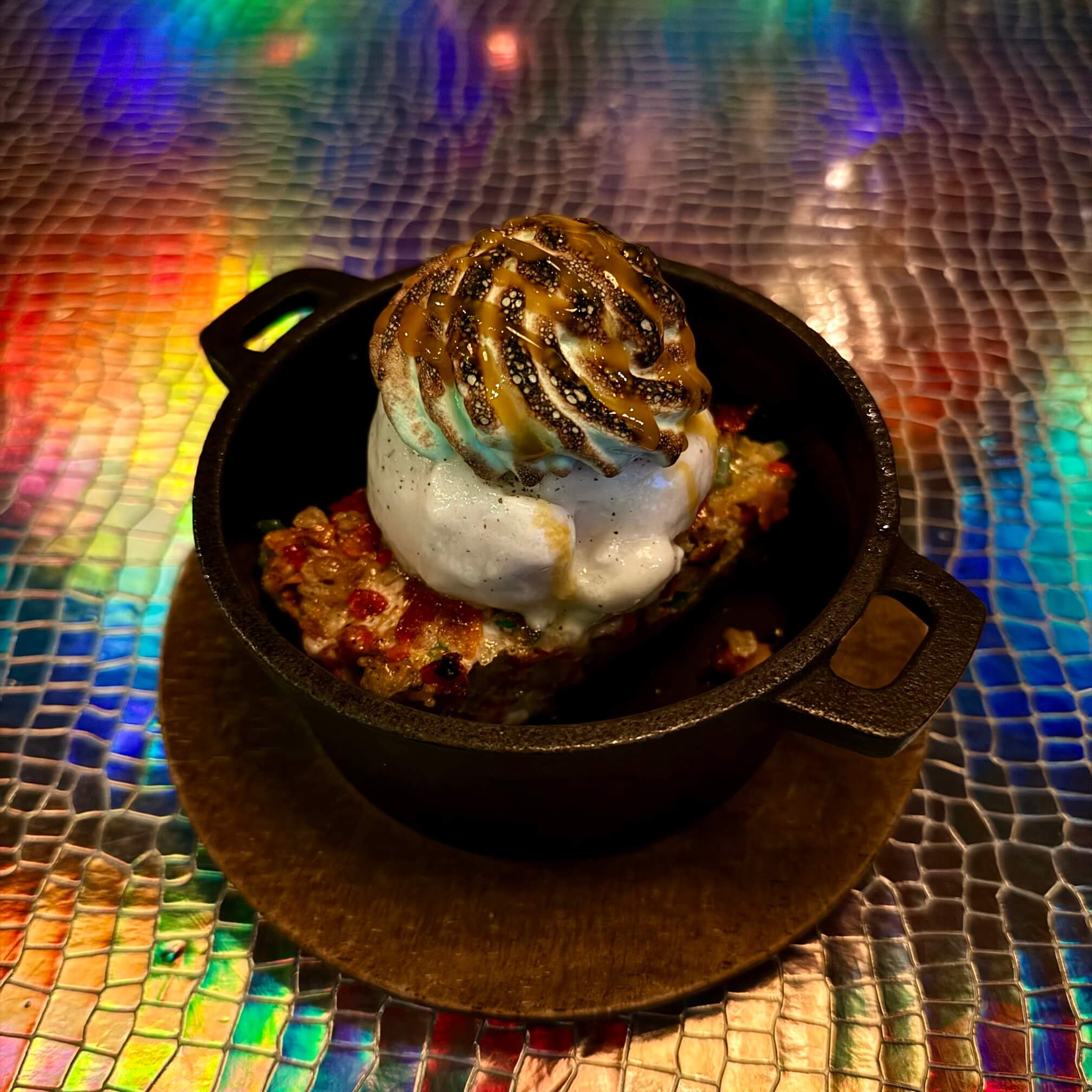 Oma’s Hideaway 套餐中的甜品：挂糖的彩色的脆米糕放在有点烫手的小铁锅里，上边是香草冰激凌、奶油和芒果糖浆。